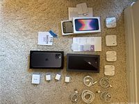 Full lot overview showing iPhone SE with boxes, multiple charging adapters, cables and headphones.