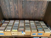 Wide view of wooden cases filled with numerous CDs organized in rows.