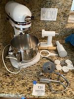 White KitchenAid Professional 5 stand mixer with bowl and accessories arranged on countertop