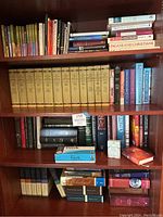 Four-shelf bookcase showing various Christian books including Expositor’s Bible Commentary set, Wiersbe volumes, and assorted study titles
