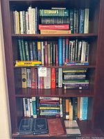 Full bookshelf showing four shelves of books and DVD courses