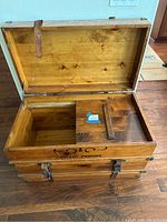 Open view of the wood trunk interior showing the removable divider panel and natural wood finish.