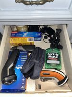 Drawer showing various hygiene and health related items including electric shavers and hygiene products.