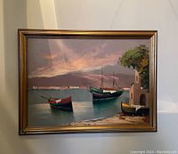 Front view of framed painting showing three boats in harbor, building with tree, and sunset background.