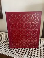 Cover of the book showing red genuine leather binding with gold geometric patterns.