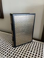 Photo showing the front cover of the book in black leather with gold geometric design.