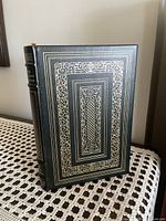 Front cover view of the leather bound book with gold decorative embossing.