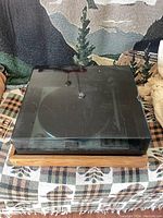 Closed tinted acrylic dust cover over faux oak veneer base