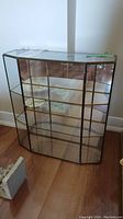 Front view of glass display cabinet showing clear glass panels and mirrored back