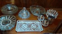 Overview of all included glass dishes and accessories displayed including square dishes, round dishes, pinwheel crystal dishes, juicer, and shakers.