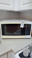 Front view of white Hamilton Beach microwave on kitchen countertop
