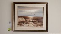 Full view of the framed oil painting showing coastal landscape with boat and seagulls