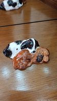 Black and white and brown dog figurines on a wooden surface