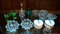 Full view showing the glass dogs, porcelain hearts, tealight holders, and crystal bell on a wooden surface.