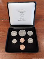 Picture of seven uncirculated Canadian coins in black velvet lined display case with Royal Canadian Mint logo inside lid.
