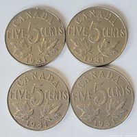 Four Canadian five cent coins dated 1931 showing the reverse side with maple leaves and denomination.