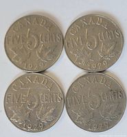 Reverse side of 4 Canadian nickels showing 5 cent denomination, two maple leaves, and date.