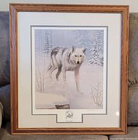 Framed artwork of a wolf in winter landscape, showing full front view of the item.