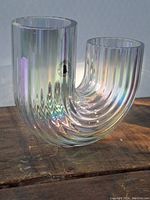Front view of the U-shaped clear glass vase with iridescent finish showing ribbed vertical wave texture