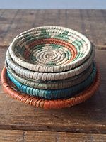 Stacked view of six woven coasters showing edges and thickness