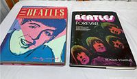 Two Beatles hardcover books side by side on a white surface, showing the full front covers and dust jackets.