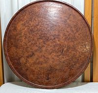 Full front view of round wooden trinket tray showing rich burl wood pattern and raised rim