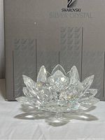 Swarovski crystal lotus flower figurine in front of the original Swarovski Silver Crystal branded box