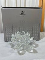 Swarovski Seerose crystal lotus flower figurine displayed in front of original Swarovski box.