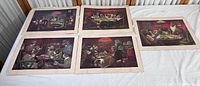 Five vintage dogs playing poker themed prints laid out on a surface showing the full set and some wear and tear.