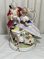 Side view of vintage porcelain figurine showing couple and table details
