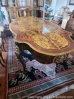 Front angled view showing violin-shaped top, inlay pattern and curved legs