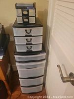 Overall stacked view of three plastic storage units with black frames and white drawers, showing size comparison and drawer details.