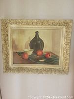Front view of the original Italian still life oil painting showing a dark bottle, bowl, and apples in an ornate carved wood frame.