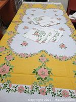Full view of retro linen tablecloth spread on table with six matching napkins folded and placed on top.