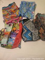 Six silk scarves displayed together showing varied colorful and patterned designs.