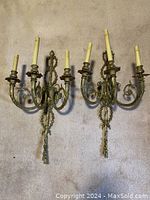Overview of both ornate metal wall sconces showing overall design and condition
