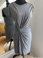 Front view of A.L.C. gray dress on dress form, showing front knot gathering and round neckline.