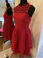 Red sleeveless lace dress on mannequin with mirror reflection