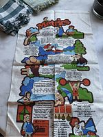 Full view of vintage metrics measurement tea towel with colorful metric conversion illustrations and cartoon characters