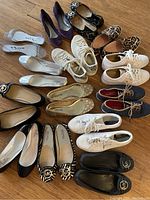 All shoes arranged on a wooden floor showing the variety of styles and brands
