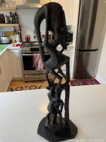 Front view of entire sculpture showing two stacked figures on irregular base