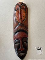 Front view of the wooden hand carved African mask showing facial features and decorative elements