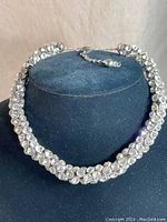 Full view of rounded rhinestone choker necklace displayed on black velvet bust, showing the overall design and length.