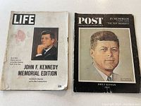 Two vintage magazines side by side: LIFE John F Kennedy Memorial Edition on left with color portrait, Saturday Evening Post In Memoriam edition on right with illustrated color portrait.