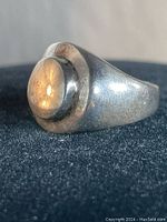 Front angle of vintage sterling silver men's ring showing raised oval dome top and patina.