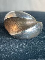 Front view of vintage sterling silver adjustable ring showing overlapped rounded band with patina and tarnishing.