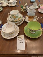 Overview photo of various fine china tea cups and saucers arranged on table