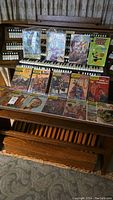 Photo showing an assortment of classic literature and vintage comic books displayed on a wooden rack. Titles include various Classics Illustrated comics and a Daffy Duck comic.