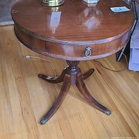 Top and side views of the round Deilcraft table showing wood finish and single drawer with handle.