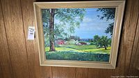 Full view of the original framed landscape painting showing trees, fields, houses, and sky.